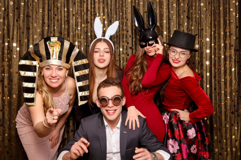Skupina hostů před flitrovým pozadím fotokoutku