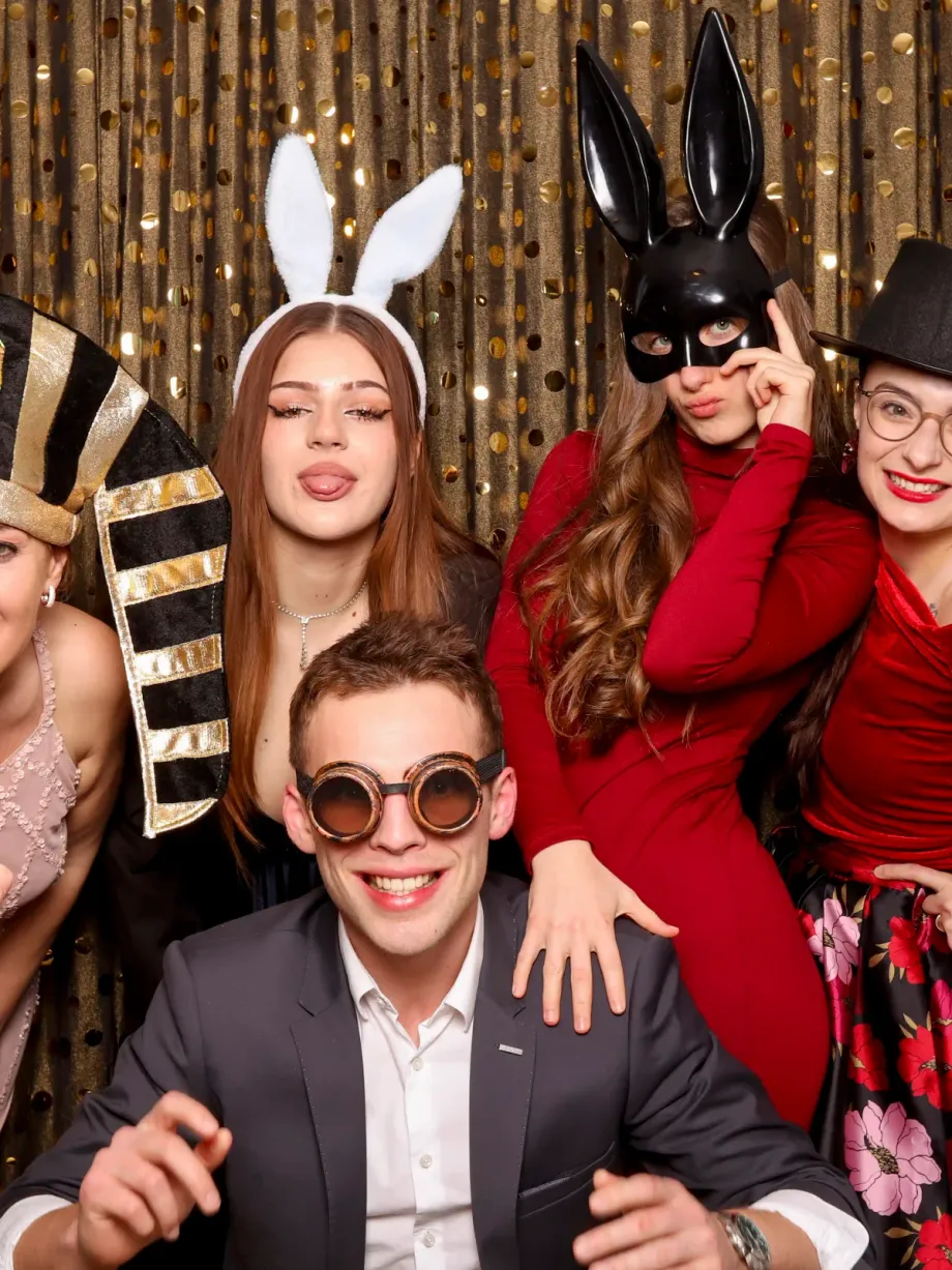 Skupina hostů před flitrovým pozadím fotokoutku
