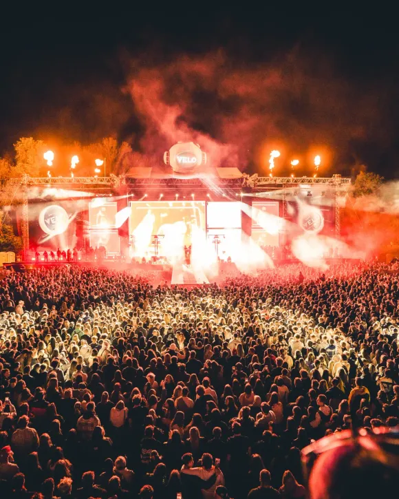 Festivalový dav v záři světlic po setmění