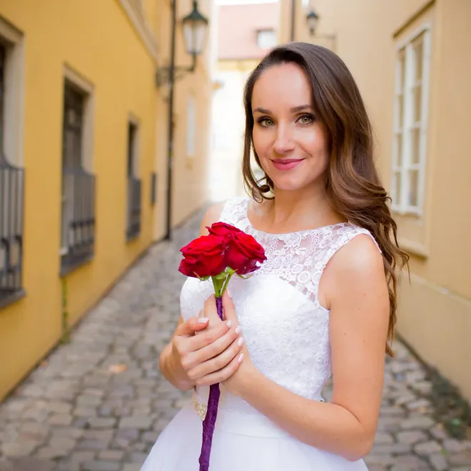 Portrét ženy s růží v uličce starého města